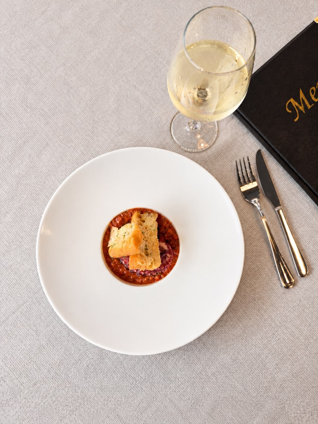 Un piatto della cena Ai Medi con un calice di vino