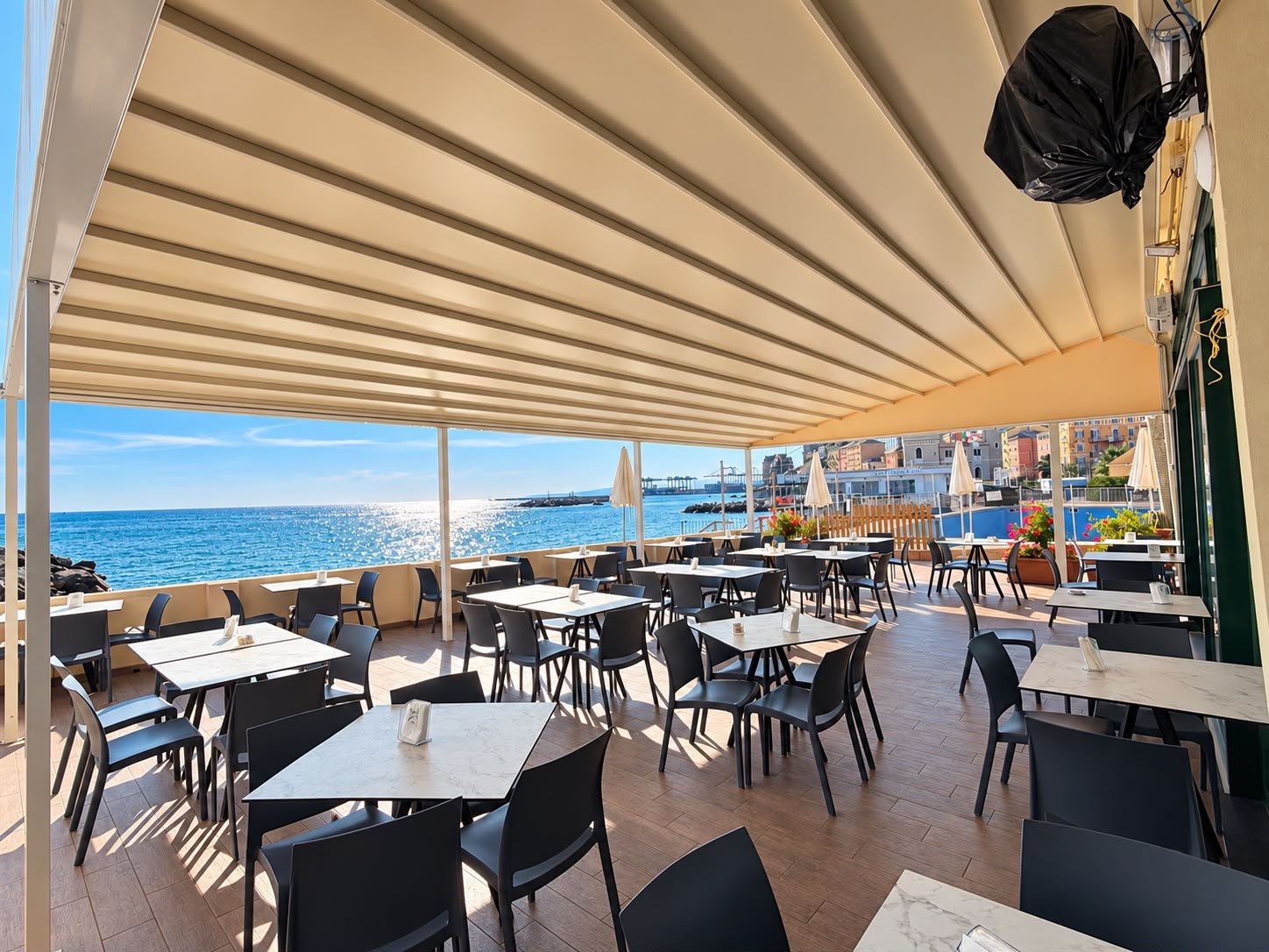 La terrazza Ai Medi sul mare, con i tavoli pronti per accogliere gli ospiti